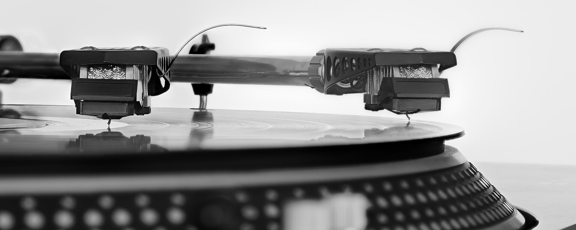 A stylus resting in the groove of a vinyl record, closely magnified.